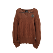 Brown sweater with a decorative brooch on a white background